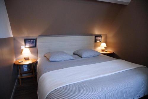 庞马尔La Dunette的一间卧室配有一张大床,桌子上放着两盏灯