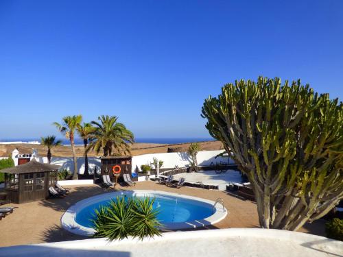 蒂亚斯Casa Berriel 1的棕榈树度假村中心的一个游泳池