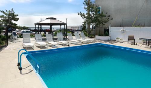 贝尔马梅费尔酒店的一个带椅子的游泳池和一个凉亭