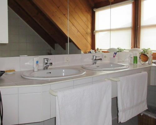 林道Gästezimmer Paul的浴室设有2个水槽和2条白色毛巾。