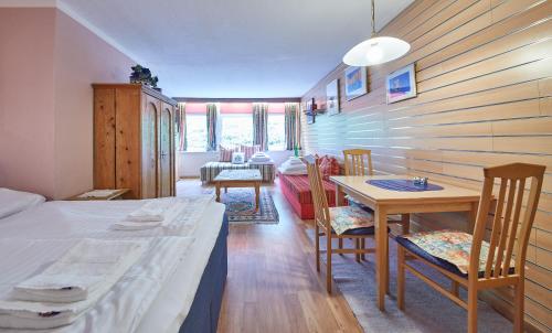 萨尔巴赫Appartements Alpin的配有一张床和一张桌子及椅子的房间