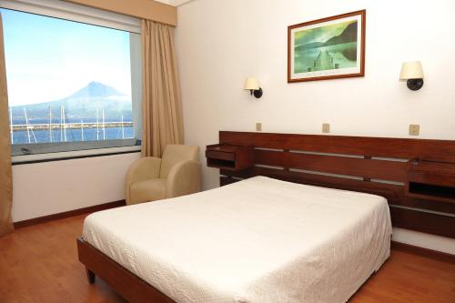 奥尔塔Hotel São Francisco的卧室配有床、椅子和窗户。