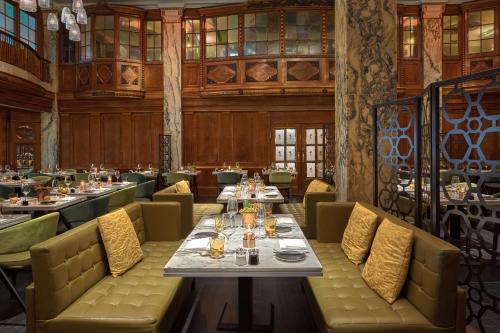 汉堡Reichshof Hotel Hamburg的餐厅内带桌椅的用餐室