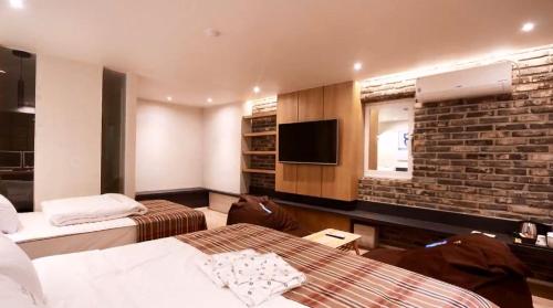 釜山凡思70酒店 的酒店客房带两张床和砖墙
