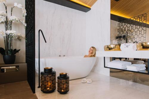 孔迪镇Casa do Rio charm suites的坐在浴室浴缸里的女人