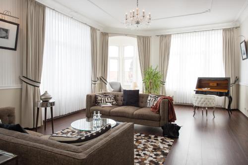 施特拉尔松德施特拉尔松德酒店的客厅配有沙发和桌子