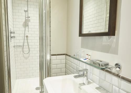 乔利Hartwood Hall by Greene King Inns的白色的浴室设有水槽和淋浴。