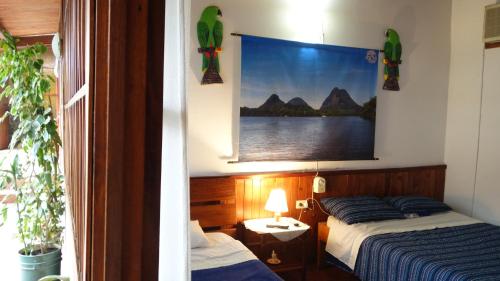 IníridaToninas Hotel的卧室配有两张床,墙上挂着一幅画