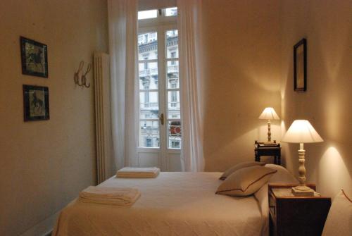 都灵玛尔佐住宿加早餐旅馆的一间卧室设有一张大床和窗户