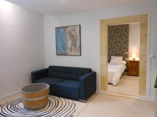 圣艾米隆杜罗伊酒店的客厅配有蓝色的沙发和床。