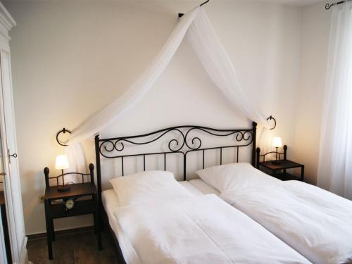 宾茨古滕贝格公寓酒店的一间带2张白色床和2个床头柜的卧室