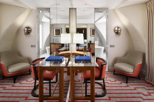 巴黎蒙塔勒贝特酒店的一间设有玻璃桌和椅子的用餐室