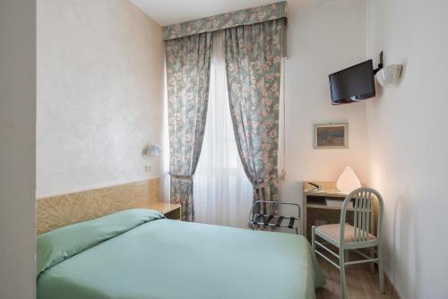 梅斯特加里波第酒店的一间卧室配有一张床和一张书桌及电视
