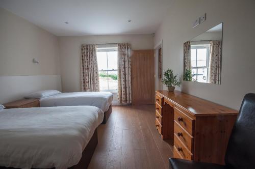 斯特拉班Strule Cottage的酒店客房,设有两张床和镜子
