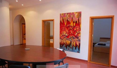 南埃福列杰约尔酒店的一间设有桌子和墙上绘画的用餐室