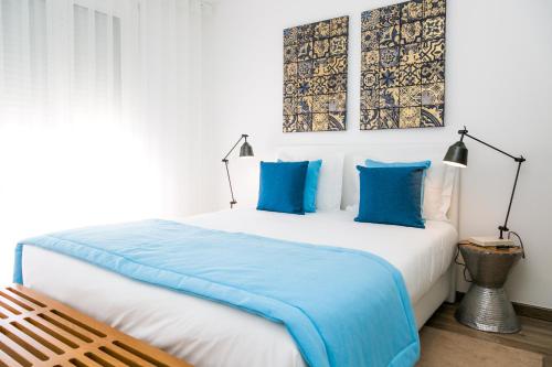 波尔图住在波尔图|舒适体验公寓的一间卧室配有一张带蓝色枕头的大床