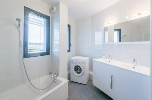 蒙彼利埃Le 180°的白色的浴室设有洗衣机和水槽。