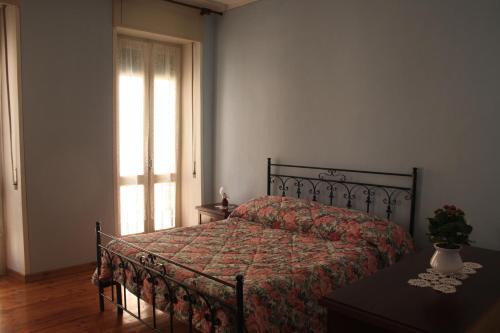 巴韦诺B&B Rosa Apartment的一间卧室配有一张带床罩的床和窗户