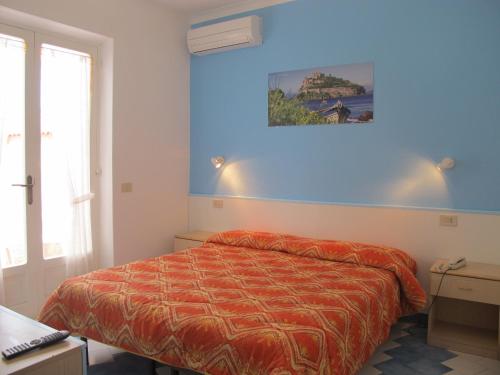 伊斯基亚Aparthotel Villa Marinù的一间卧室设有一张床和蓝色的墙壁