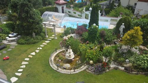 TrebesingFerienwohnungen Garten Eden的一个带喷泉和游泳池的小型花园