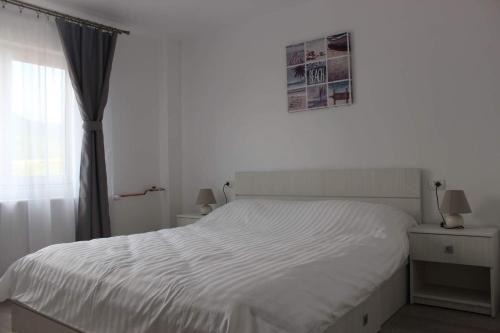 克利默内什蒂Apartament Anais的卧室内的一张白色床,设有窗户
