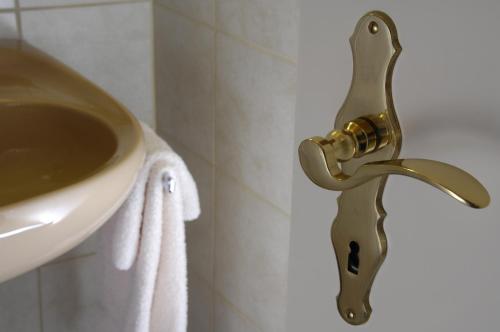 Trun卡萨托迪餐厅酒店的浴室内水槽旁的黄铜水龙头