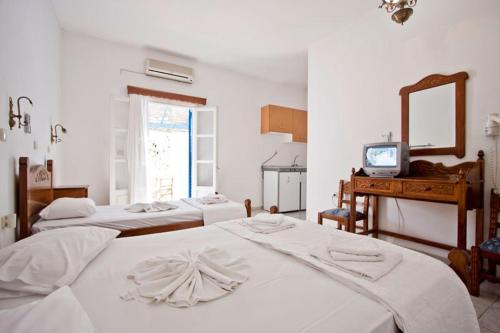 卡塔波拉Hotel Landeris的一间卧室配有四张白色的床和电视