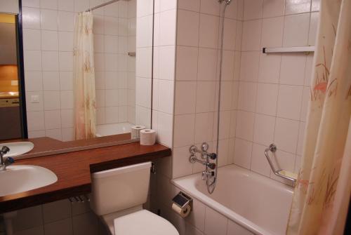 迪森蒂斯豪斯阿克莱塔度假公寓的浴室配有卫生间、浴缸和水槽。