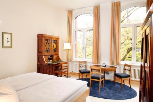 柏林Gäste- und Tagungshaus am Glockengarten的一间卧室配有一张床、一张桌子和一张桌子