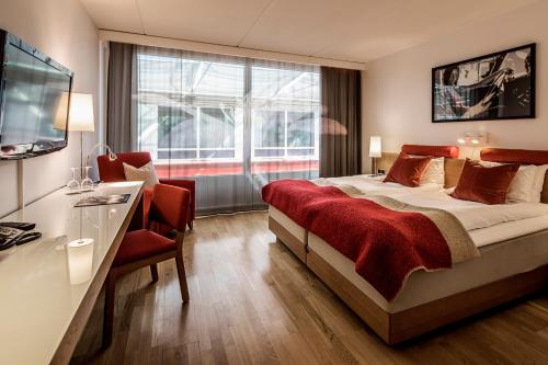 哥德堡第一酒店G的酒店客房配有一张床、一张书桌和一台电视。