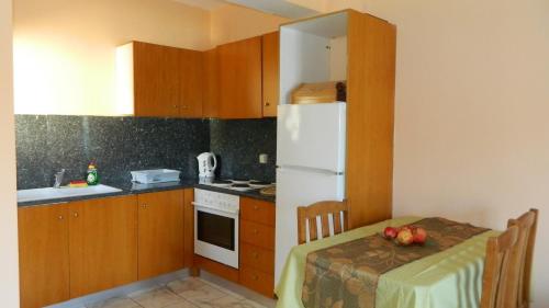 瓦西Forkis Apartments的一间带桌子和白色冰箱的小厨房