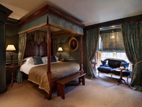 伦敦黑兹利特酒店的一间卧室配有天蓬床和蓝椅