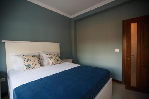 康斯坦察Bliss Residence - Aquamarine的一间卧室配有一张带蓝白色毯子的床