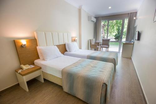 伊兹密尔巴科瓦温泉酒店的酒店客房设有两张床和一张桌子。