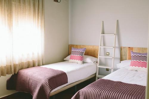 贝哈尔ALTAIR Turismo Rural的一间卧室设有两张床和书架