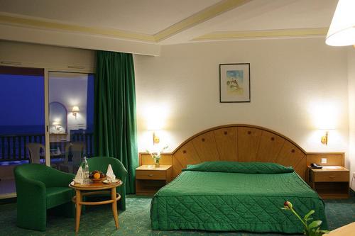 哈马马特艾尔毛拉第哈马马特酒店的一间卧室配有绿色的床和绿色椅子