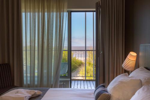派尔努赫敦温泉酒店的一间卧室设有一张床,享有阳台的景色