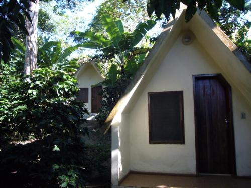 乌巴雅拉Chalés Sítio do Alemão的一间白色的小房子,设有棕色的门