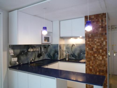 普拉加德阿罗Tramuntana的厨房配有白色橱柜和蓝色台面