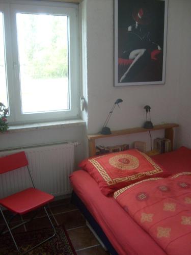 弗莱堡时爱特爱木埃克民宿的一间卧室设有红色的床和窗户。