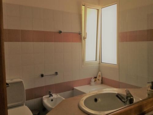Madalena do MarApartamento Vai Vem的一间带水槽和卫生间的浴室以及窗户。