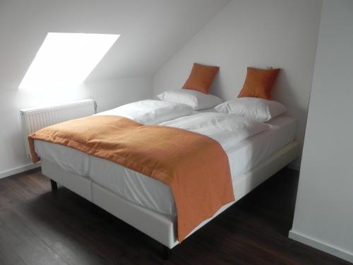 费伦德孔斯特酒店 - 餐厅的一张白色的床,上面有橙色毯子