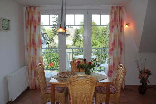 青斯特Ferienwohnung Strandmuschel的一间带桌椅和窗户的用餐室