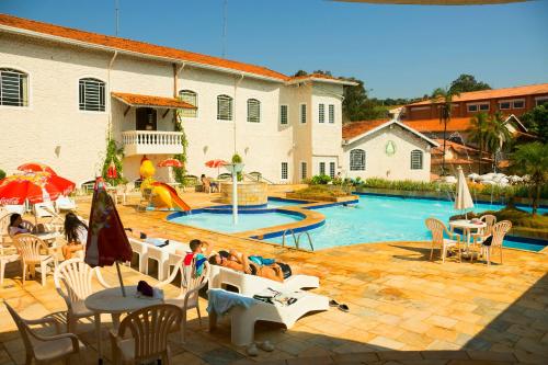 圣代佩德罗Hotel Fazenda Fonte Colina Verde的一群人坐在游泳池边的椅子上
