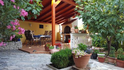 皮罗瓦茨Villa Manja的庭院里种植了盆栽植物,配有桌椅