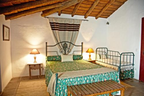 蒙萨拉什Casa Saramago的一间带一张床的卧室,位于带木制天花板的房间内