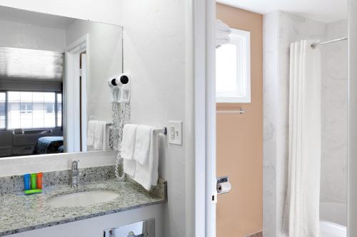尤金市区旅馆的一间带水槽和镜子的浴室