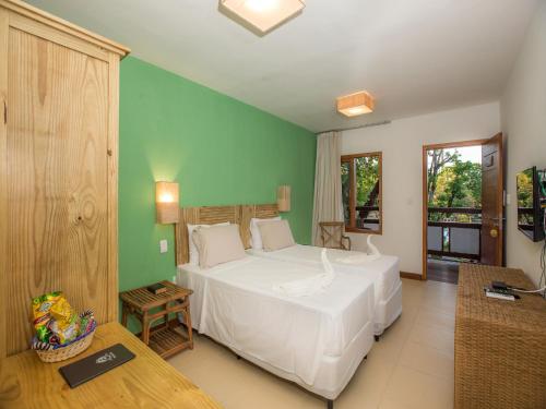 普拉亚多Pousada Paraíso do Forte的卧室配有白色的床和绿色的墙壁