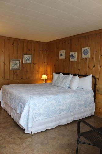 法尔茅斯小镇海滩汽车旅馆的一间卧室配有一张带木墙的大床