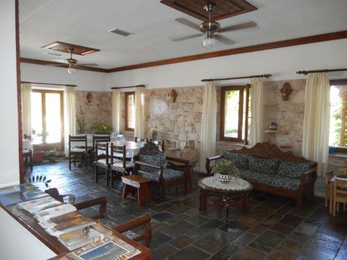 毕达哥利翁Pythaïs Hotel的客厅设有桌椅和窗户。